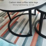 Modern white marble nesting coffee table with black steel base in a minimalist living room