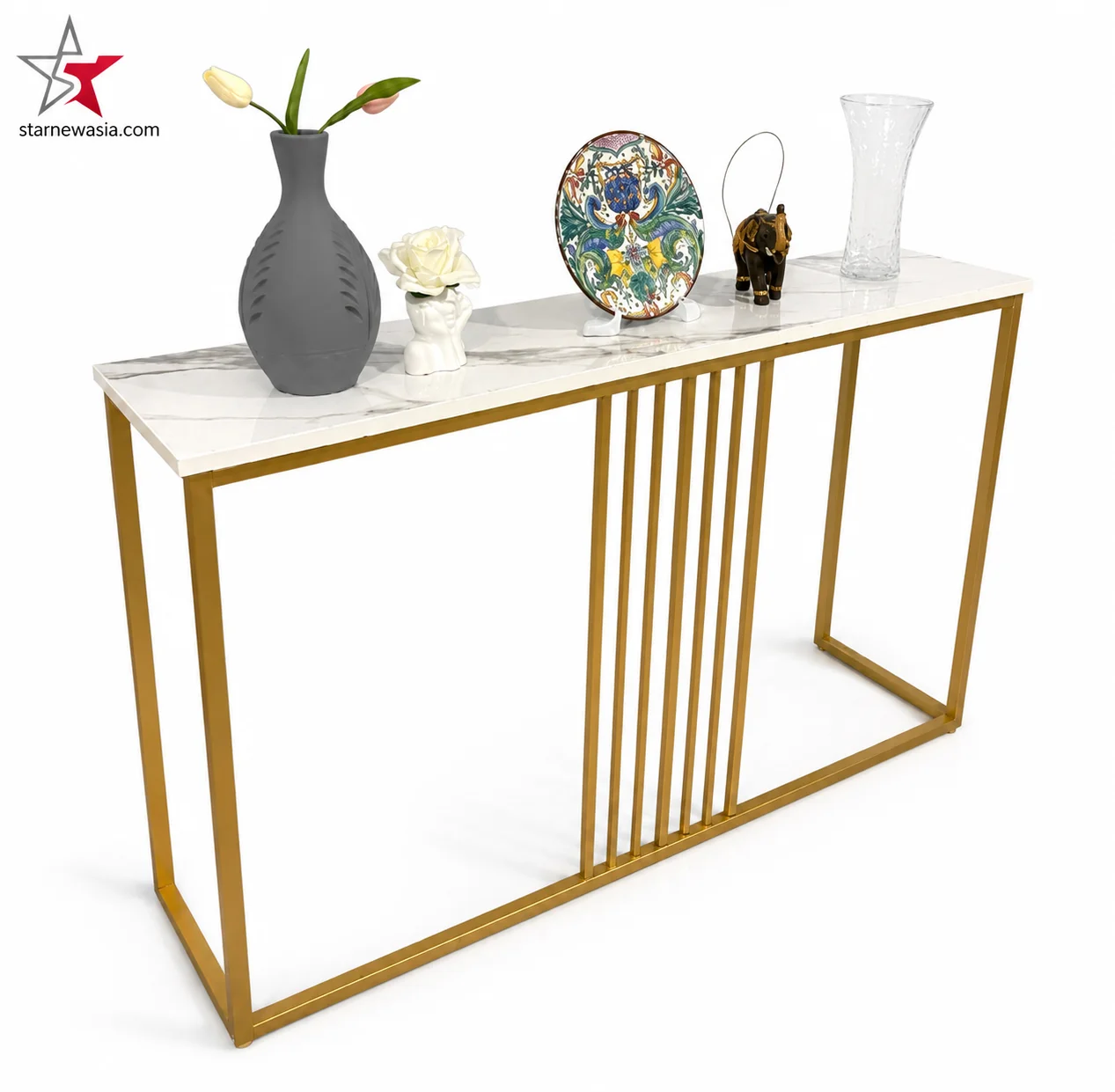 starnewasia.com watermark on a luxury white gold console table with a sleek three-panel drawer front, a polished gold intersecting X-frame base, styled with golden jars and decorative vases.